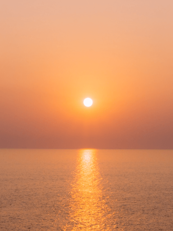 Photo d'un couchée de soleil sur la mer.