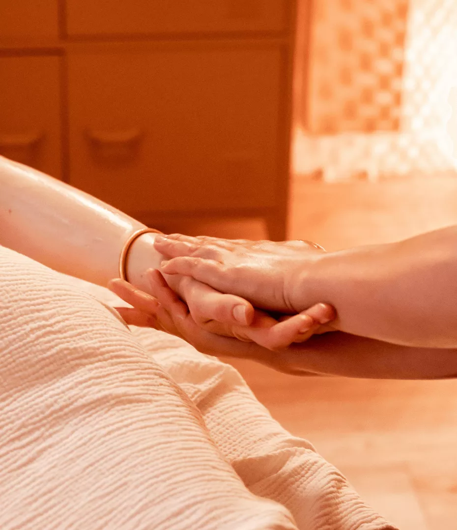 Les mains de la masseuse enveloppe la main de la cliente comme un gant et glisse de son bras jusqu'à ses doigts.