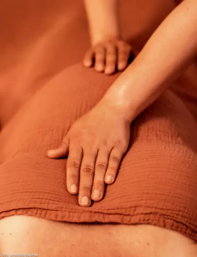 Photo de deux mains posé sur le buste et ventre d'une femme enceinte lors d'un soin énergétique.