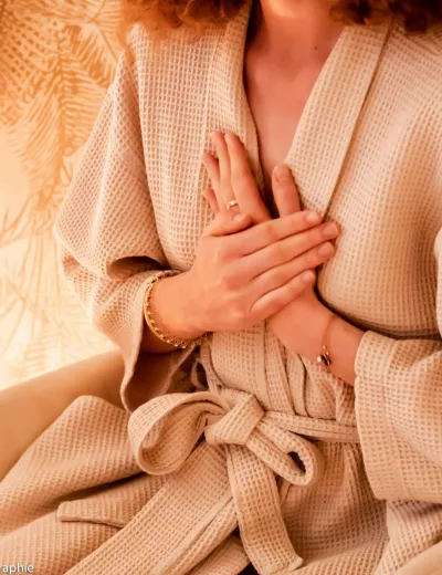 Photo d'une personne assise les mains croisée sur son cœur.